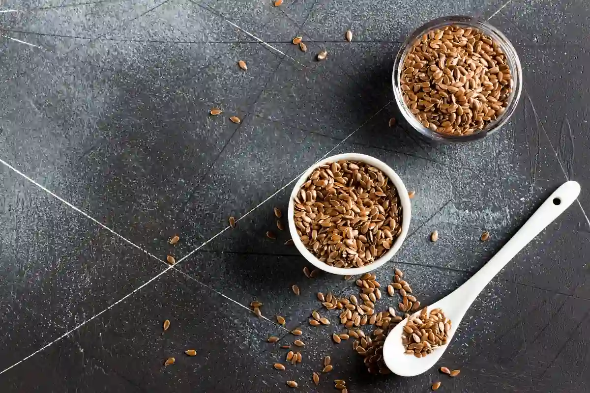 Flaxseeds in bowls and on a spoon.